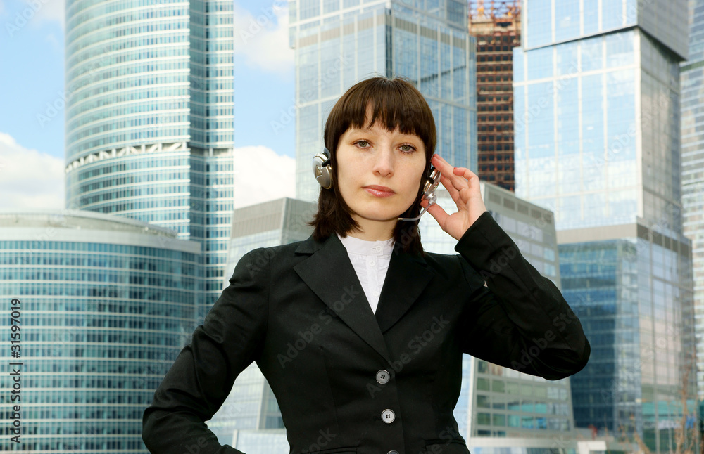 Business woman with headset on city background Business woman with headset on city background