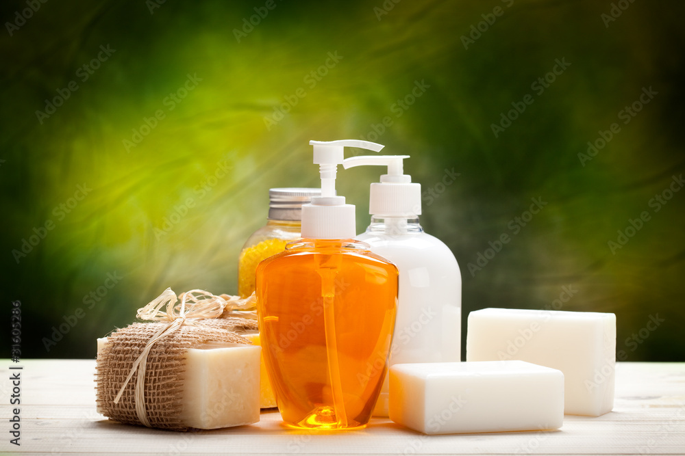 Liquid soap and soap bars on green background Liquid soap and soap bars on green background