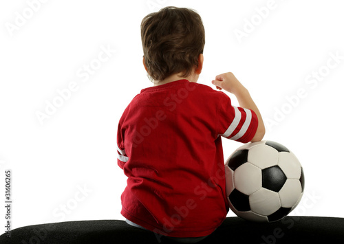 child with soccer ball sitting back