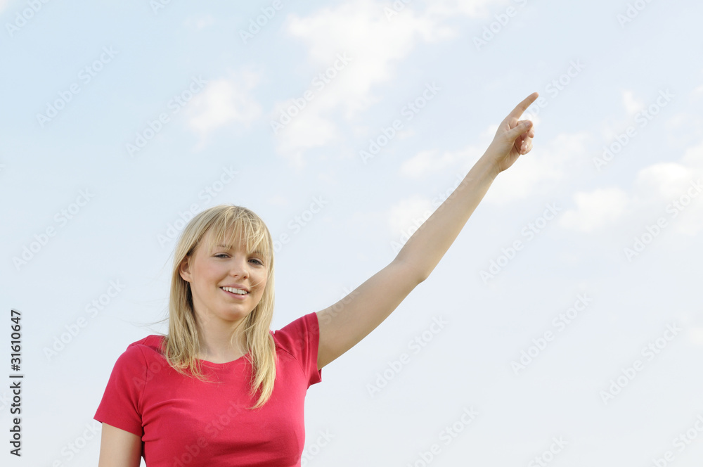 Fototapeta premium junge frau zeigt in den himmel