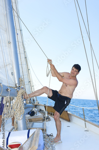 mature man smiling while hoisting the sail