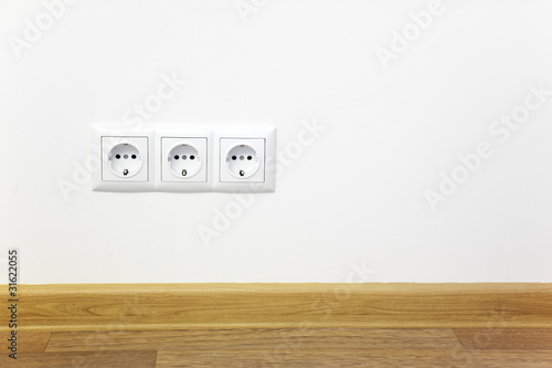 Empty interior white wall with power outlet