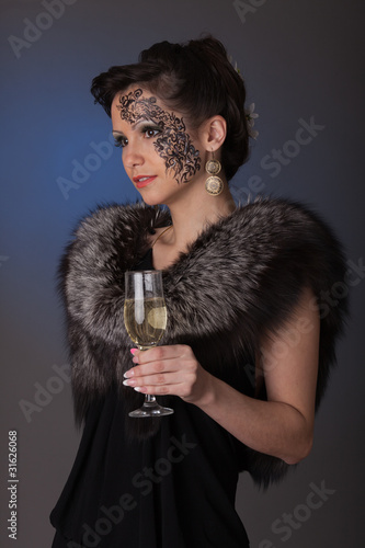 Young woman in furs with a glass of champagne.