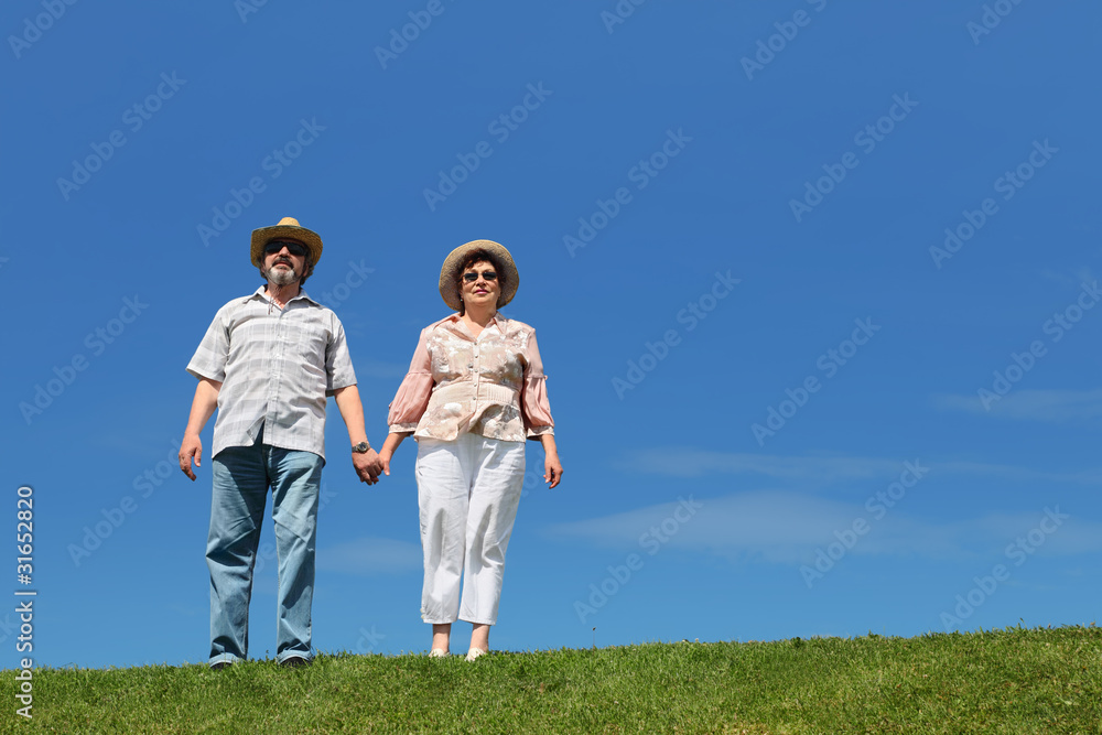 old man and woman in straw hats and sunglasses standing old man and woman in straw hats and sunglasses standing