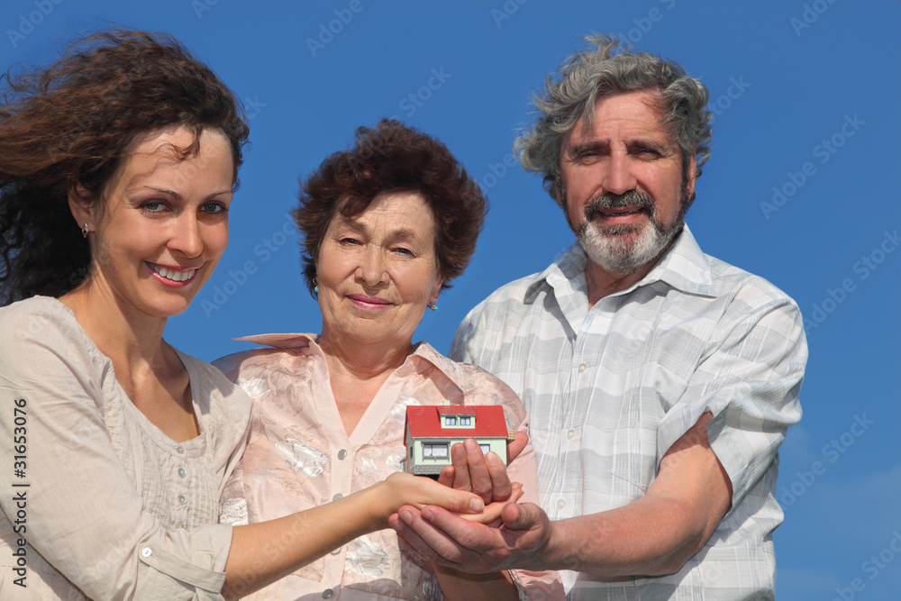 daughter and parents holding house model and smiling daughter and parents holding house model and smiling