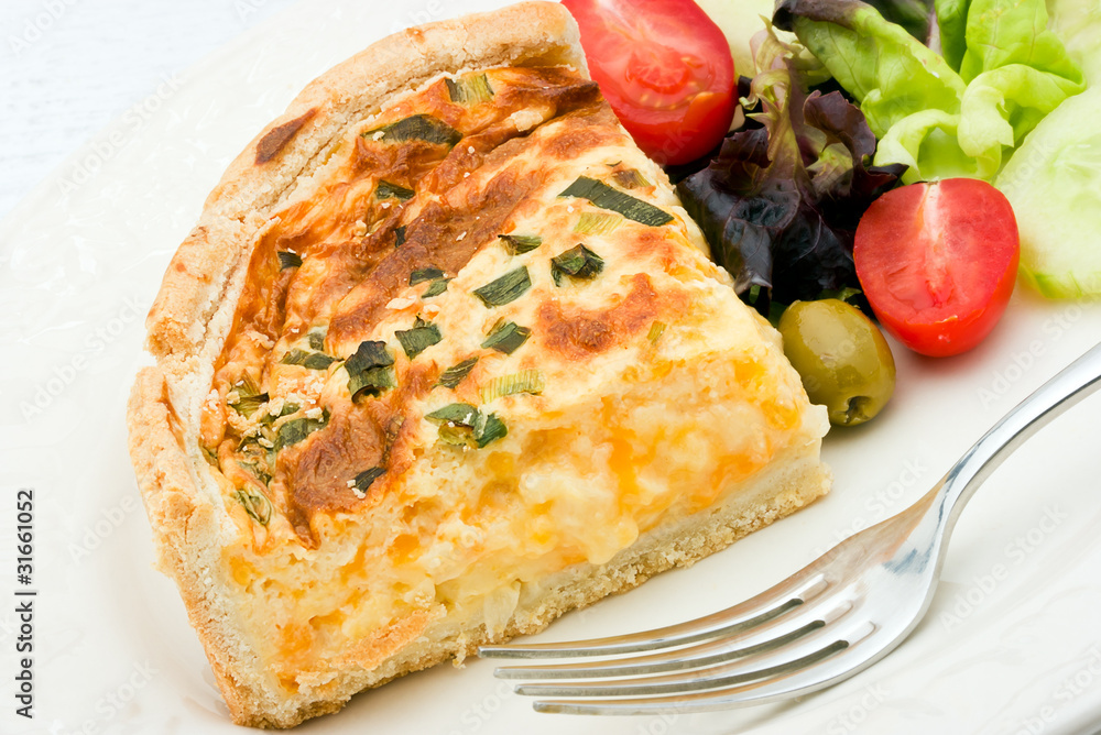 Quiche with salad on a white plate.