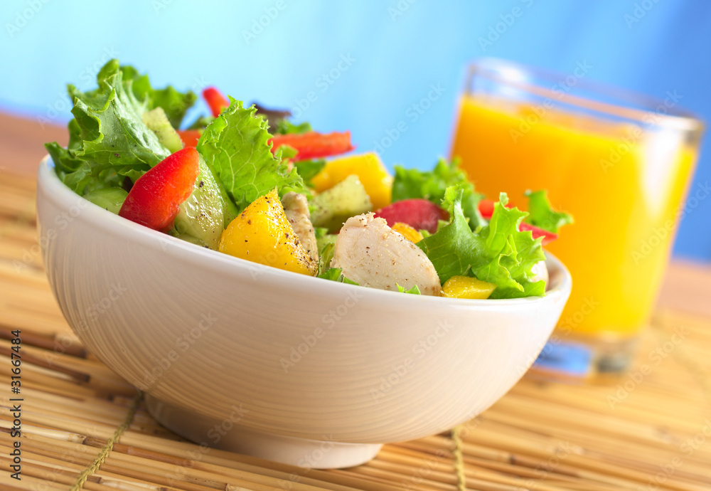 Chicken salad with lettuce, mango, bell pepper and cucumber