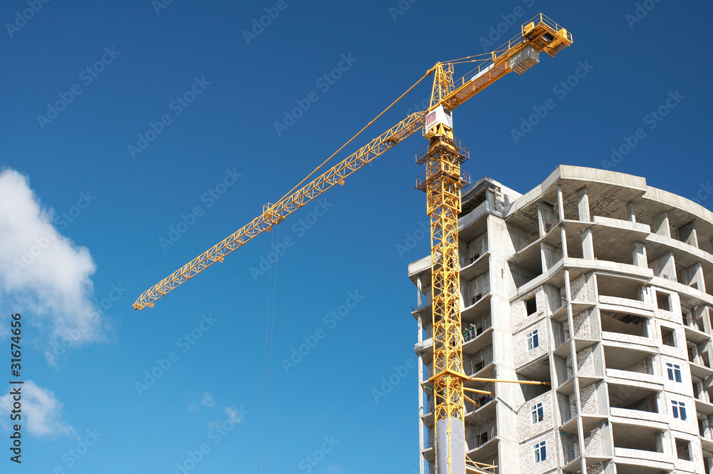 track crane with a house under construction track crane with a house under construction