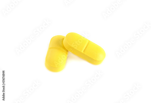 two close-up isolated yellow pills, tablets