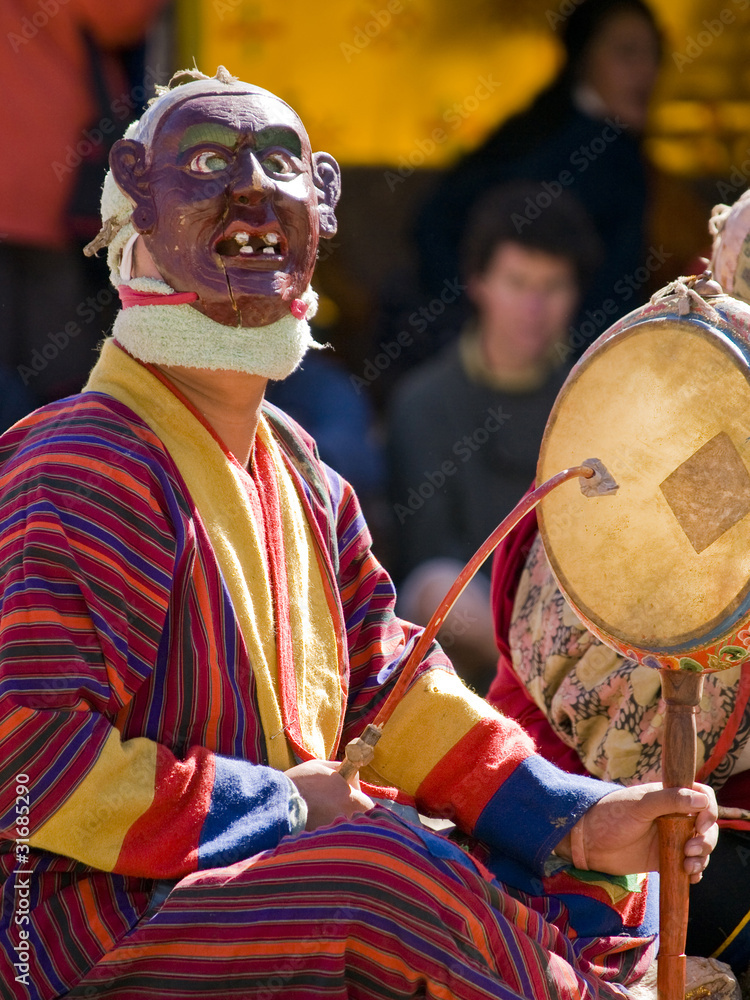 Bumthang, Bhutan - October 2010: A masked man making music durin