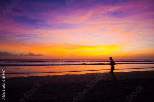 Female runner silhouette  with a soft pastel sunset sky and sea
