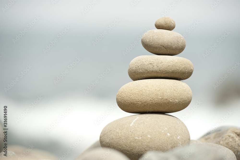 pile of balanced rocks on stony beach ocean background pile of balanced rocks on stony beach ocean background
