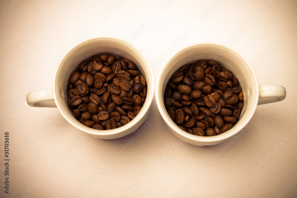 two cups with coffee beans two cups with coffee beans
