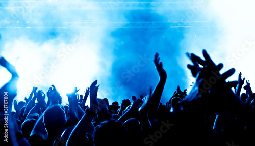 concert crowd in front of bright blue stage lights