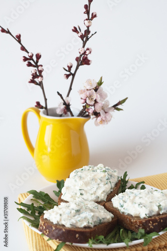 Cheese snack on rye bread and a bouquet