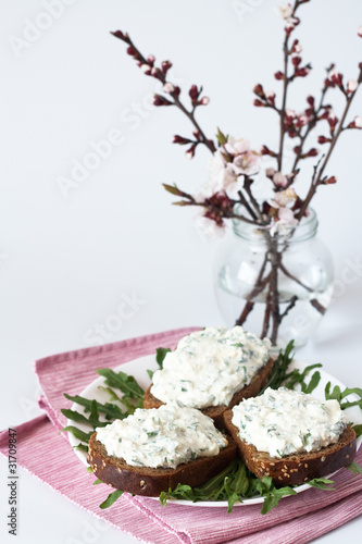 Cheese snack on rye bread and a bouquet