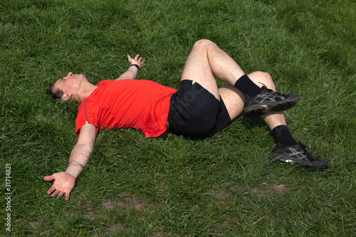 Runner exercising and stretching on grass