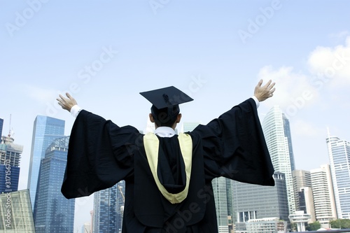 Behang Graduate outstretched arms with urban background