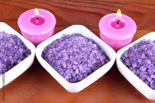 Lavender spa salt and lavender candles on a wooden background