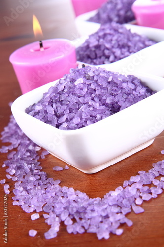 Lavender spa salt and lavender candles on a wooden background