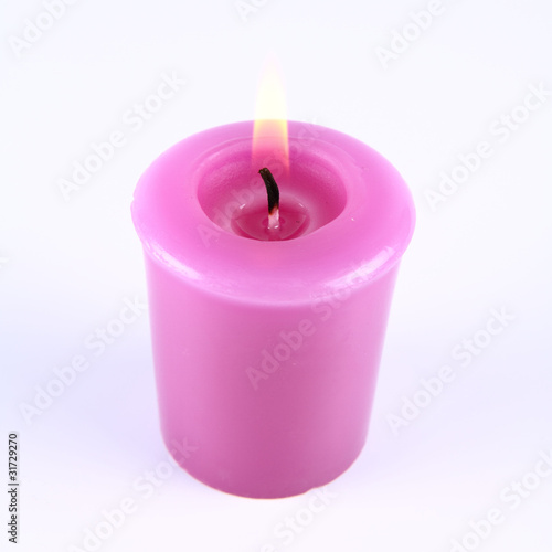 Lavender candle burning on a white background