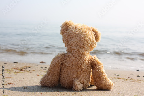 Teddybär einsam am Strand - Symbol für Single-Urlaub, etc.