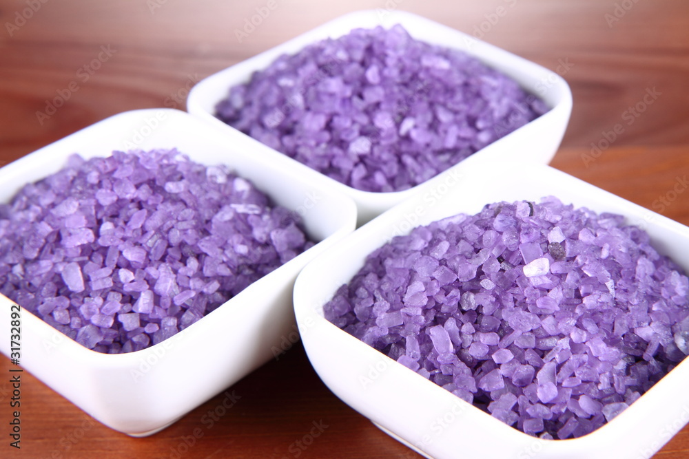 Lavender spa salt in white bowls on a wooden background Lavender spa salt in white bowls on a wooden background