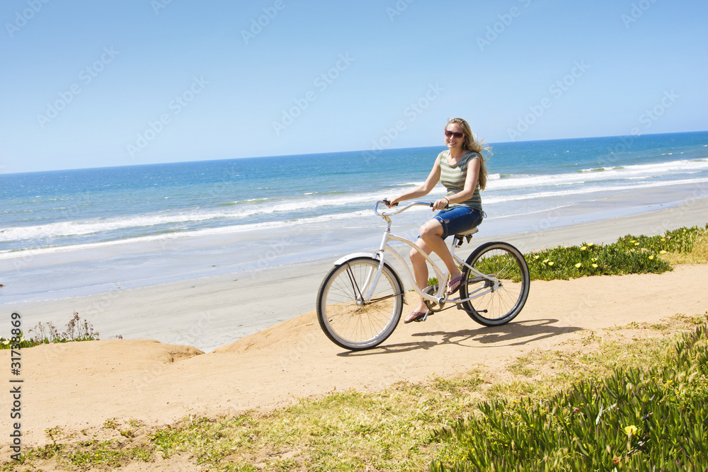 Fototapeta premium Beautiful Woman on a Bicycle Ride along the beach