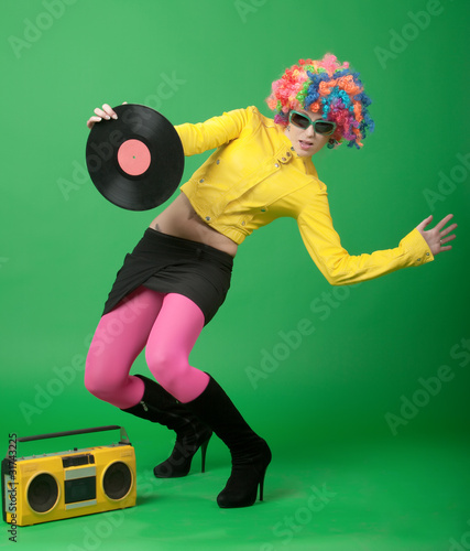 The girl in a color wig with a disk and tape recorder