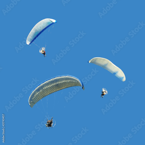 White blue paramotor on blue sky
