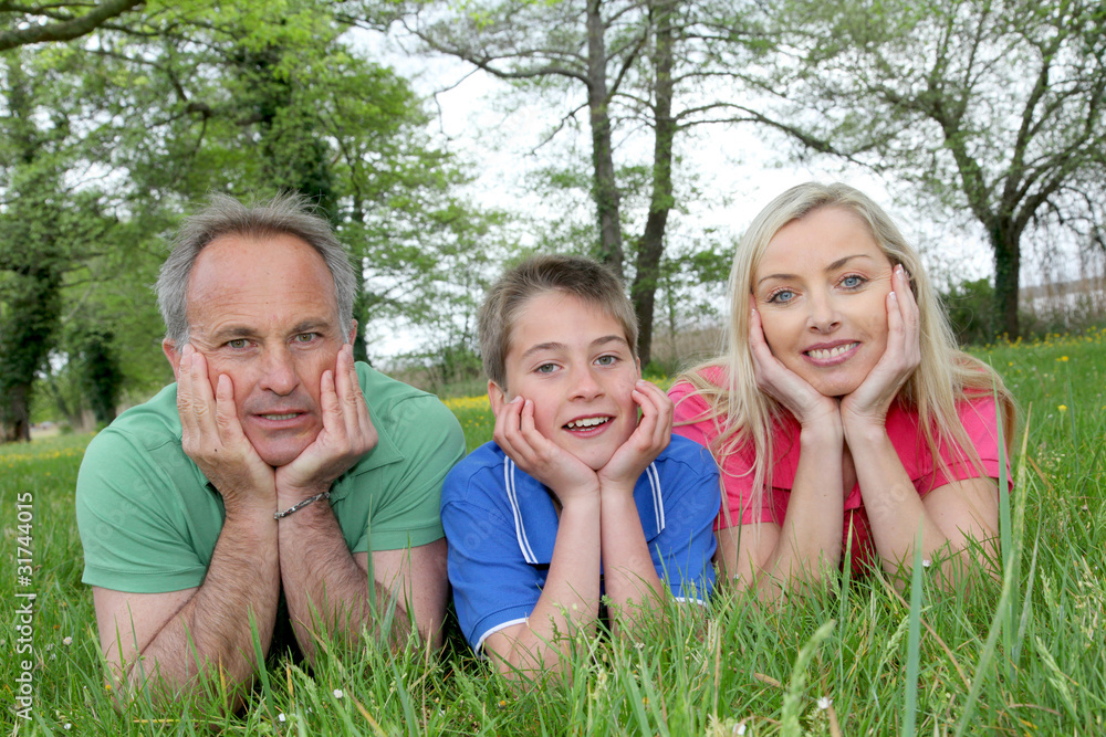 Portrait of happy family laying in grass Portrait of happy family laying in grass