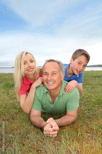 Portrait of happy family laying in grass © goodluz