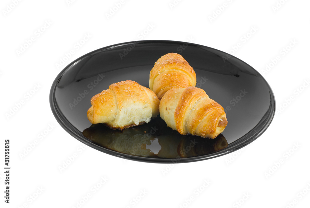Three small croissants on a black plate. Three small croissants on a black plate.