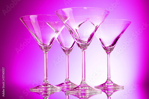 empty glasses of martini on purple background