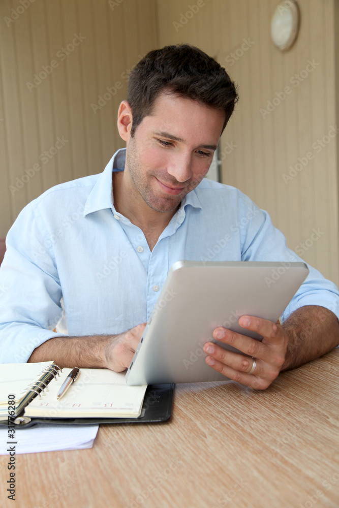 Man working at home with electronic tablet