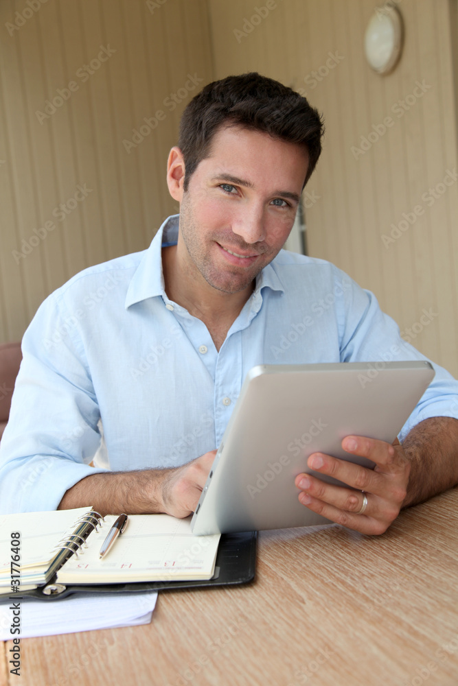 Man working at home with electronic tablet Man working at home with electronic tablet