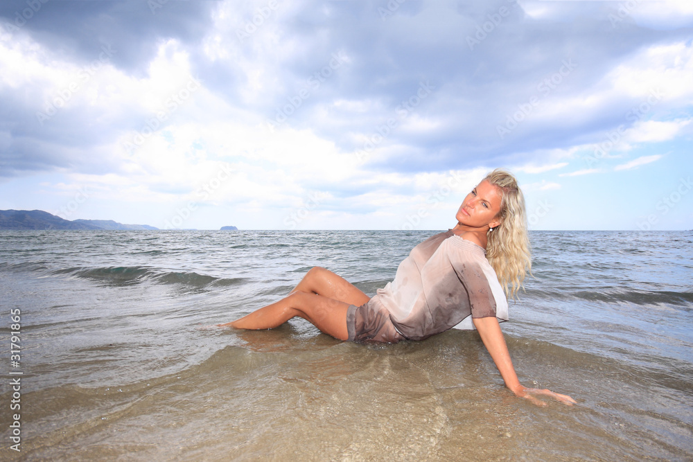 Young beautiful woman posing on the beach Young beautiful woman posing on the beach