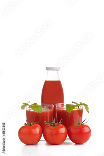 Zwei Gläser mit Tomatensaft und Reihe Tomaten