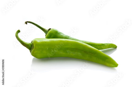 Two green chili on white background