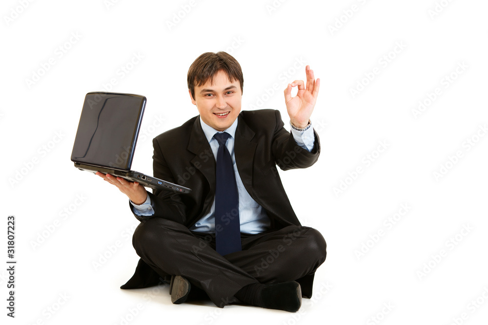 Sitting on floor with laptop businessman showing ok gesture Sitting on floor with laptop businessman showing ok gesture