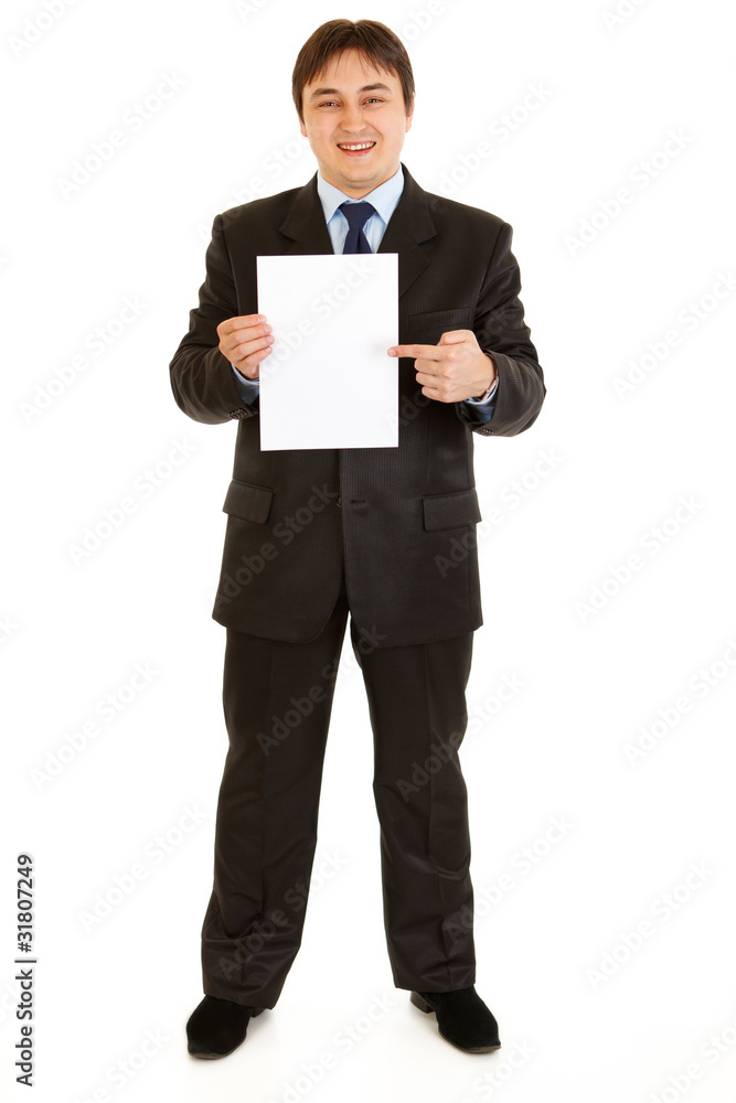 Smiling modern businessman pointing at white paper Smiling modern businessman pointing at white paper