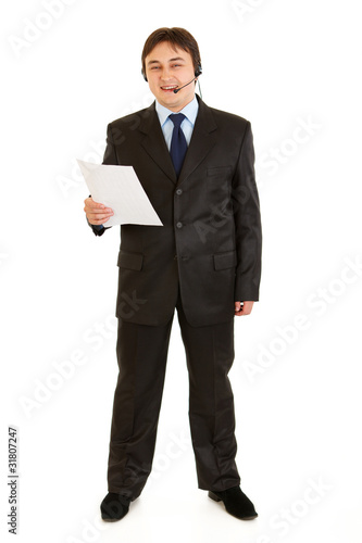 Smiling businessman with headset holding document in hand