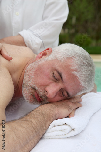 Portrait of senior man laying on a massage bed