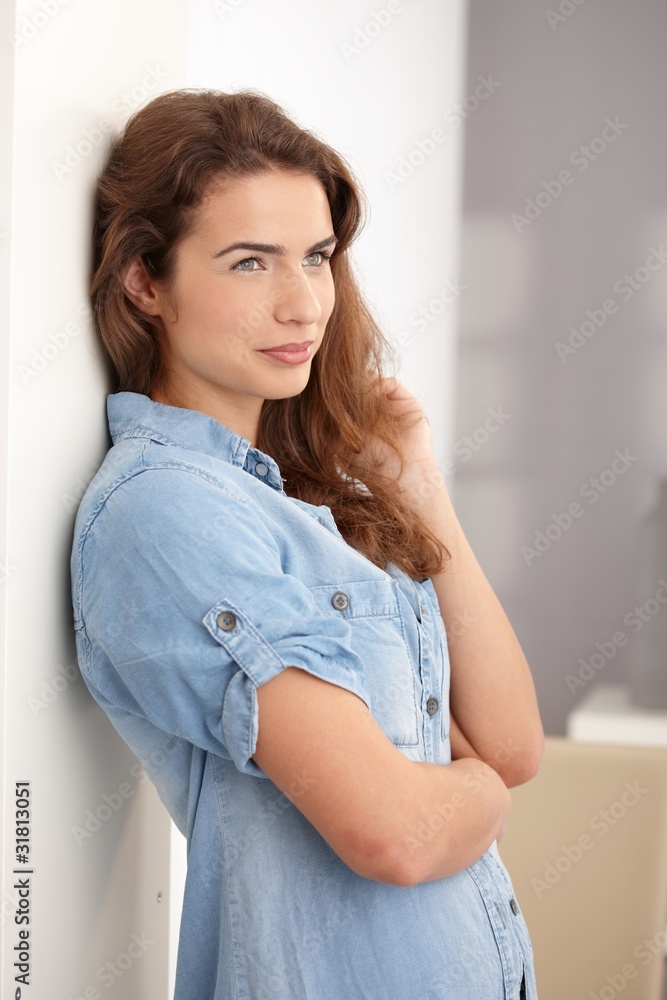 Naklejka premium Young woman standing at wall smiling