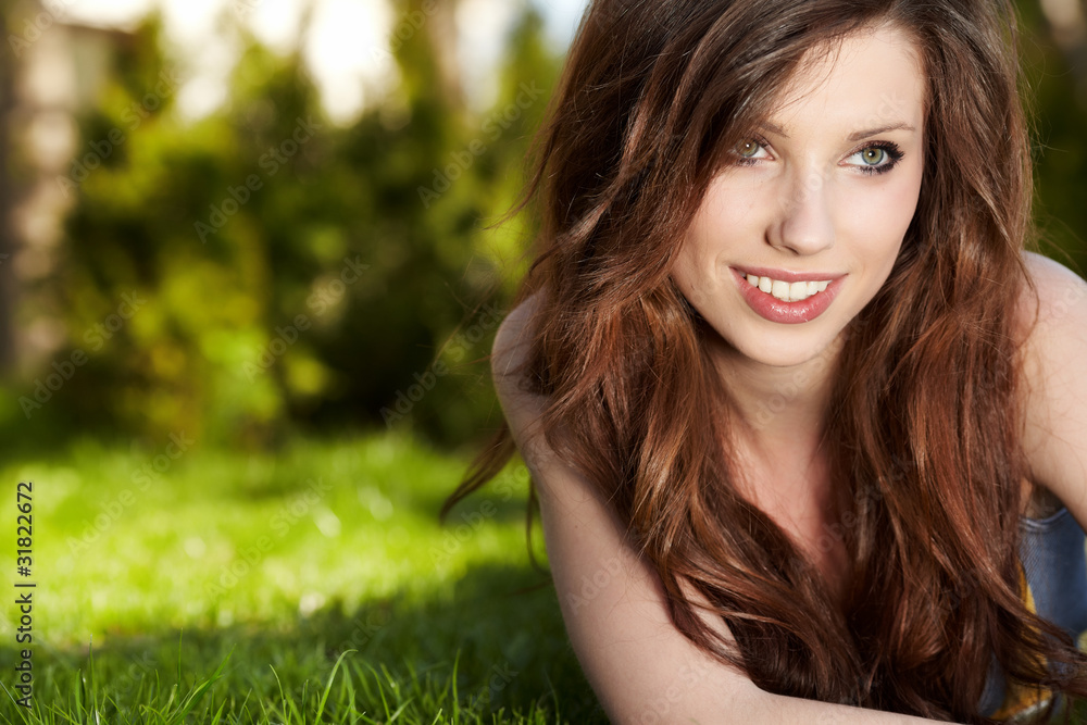 Smiling beautiful woman laying on grass