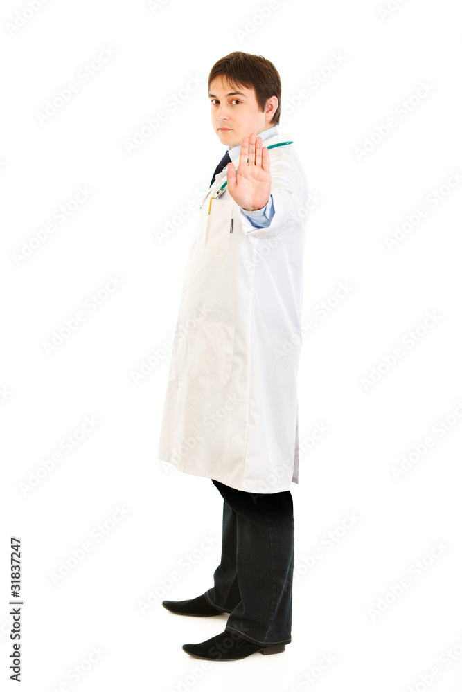 Full length portrait of medical doctor showing stop gesture Full length portrait of medical doctor showing stop gesture