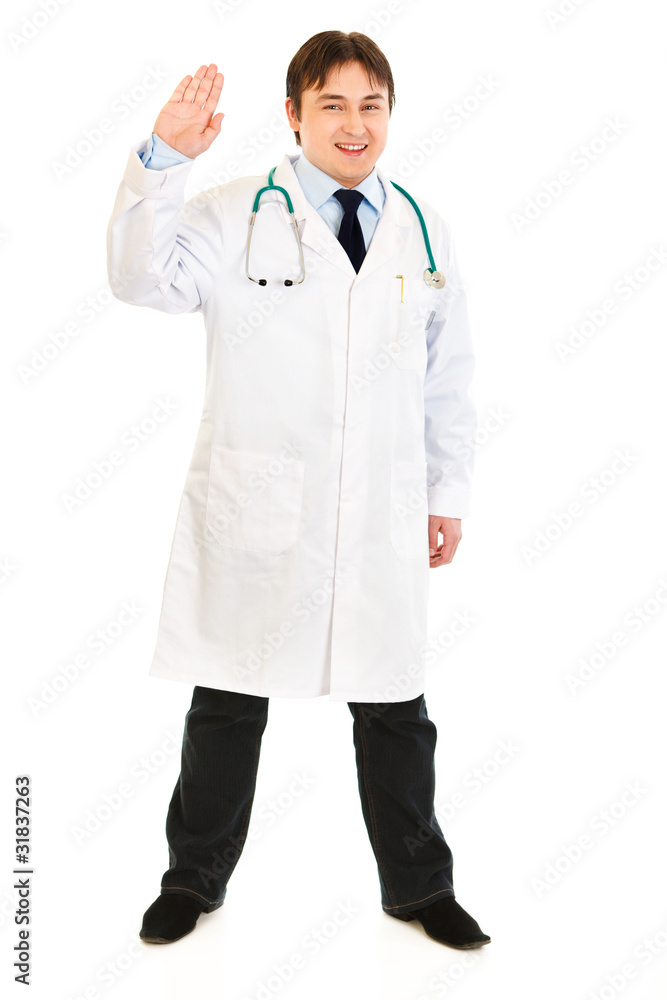 Full length portrait of smiling doctor showing salutation Full length portrait of smiling doctor showing salutation