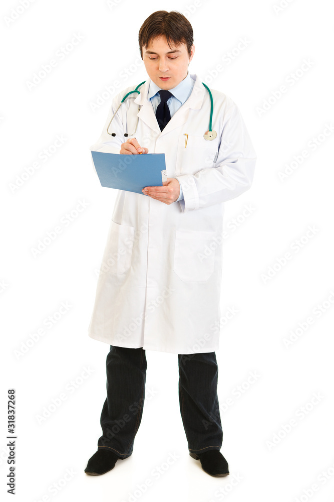 Serious making notes in medical chart isolated on white. Serious making notes in medical chart isolated on white.