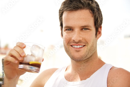 Young handsome man having a drink outdoors