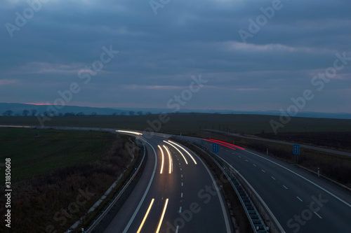 Cars moving fast on a night highway (motion blurred image)